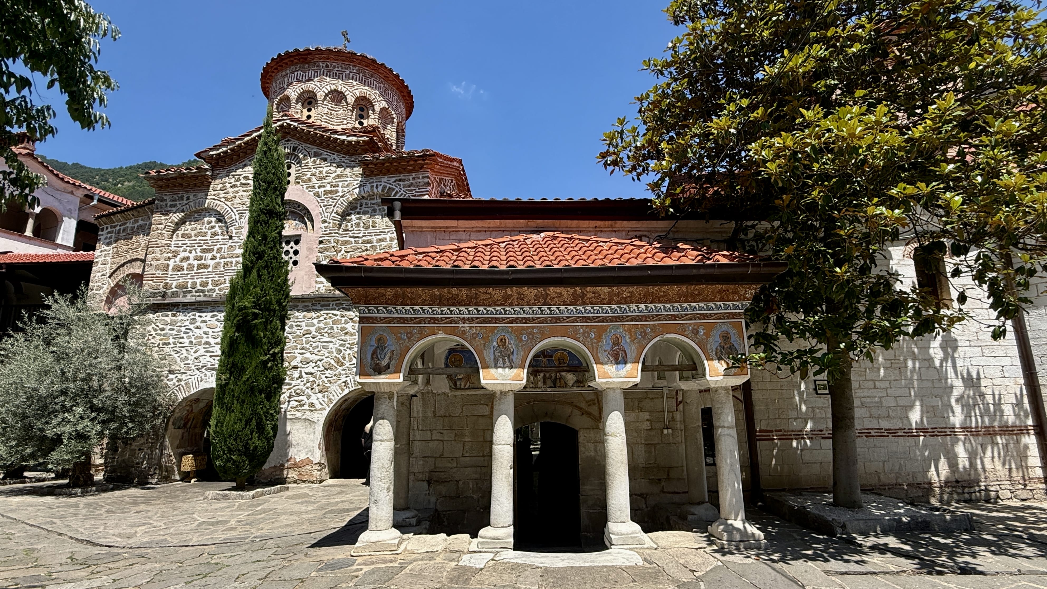 Bachkovo Monastery with its stone church, red-tiled roofs and painted arches in Bulgaria
