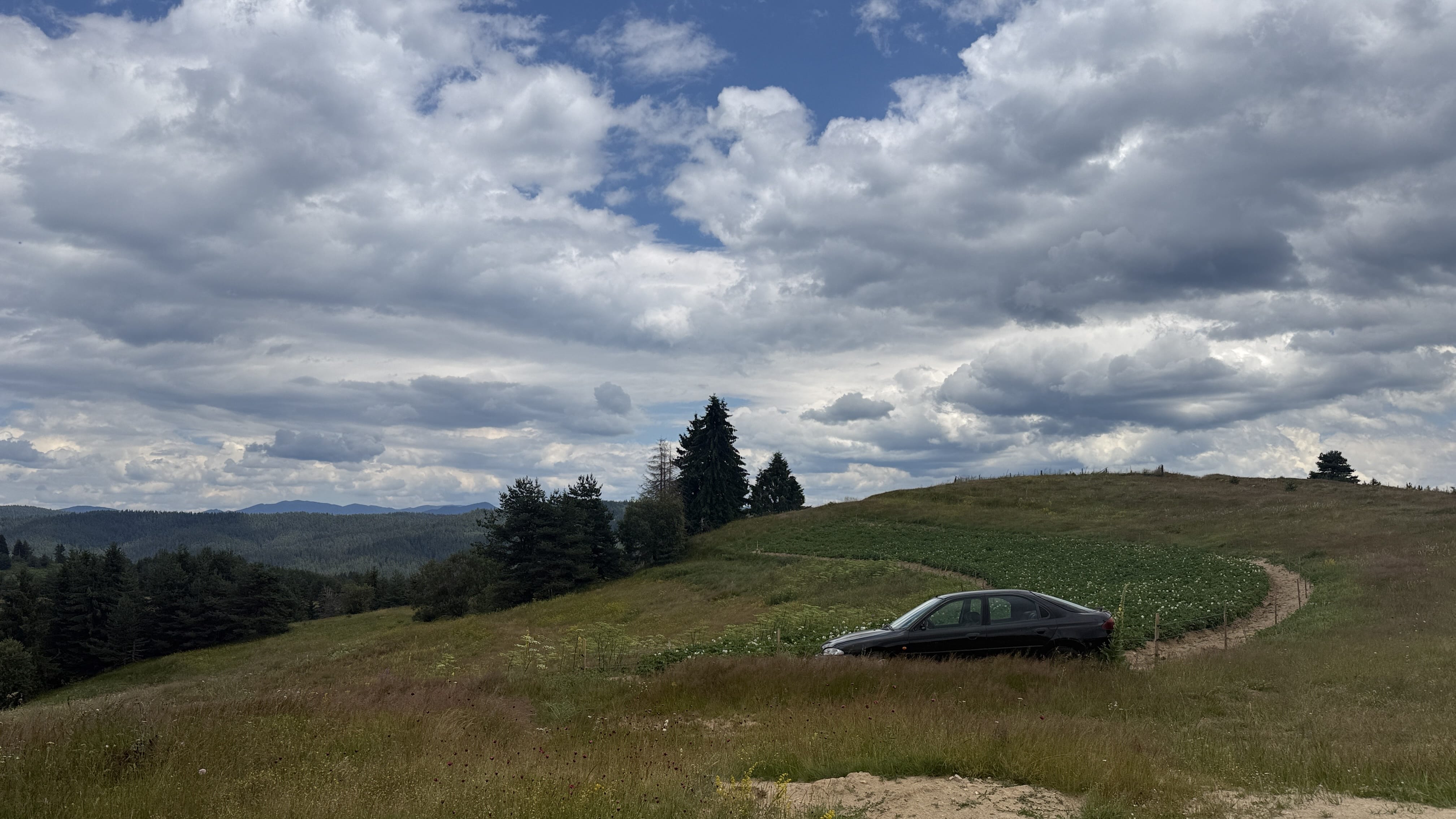 Car beside a potato field in Bulgaria’s Rhodope Mountains used to power an electric fence