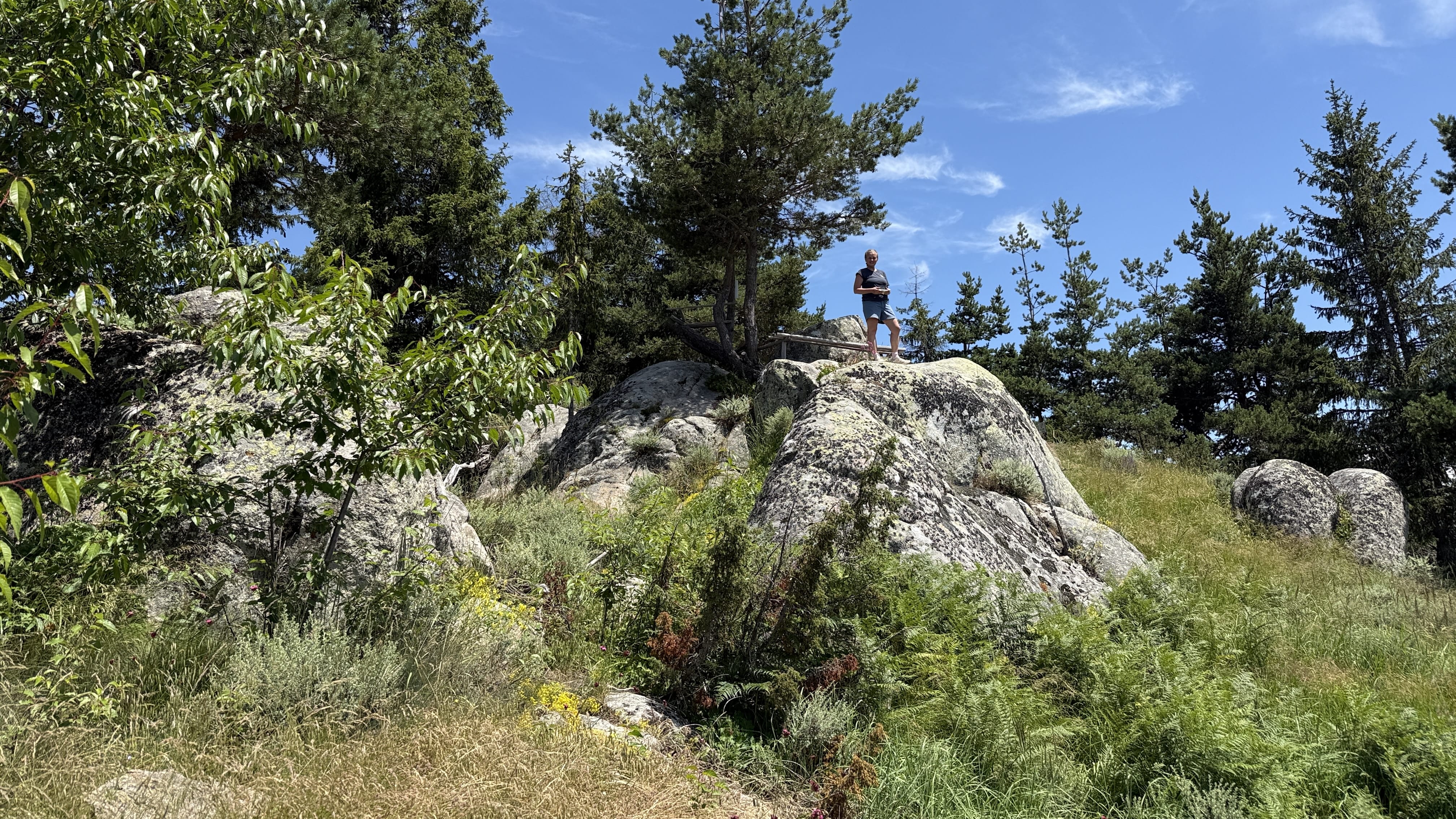 Hiker standing on a rocky summit in Bulgaria’s Rhodope Mountains